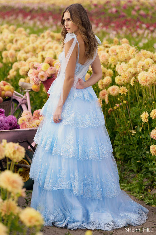 This ballgown features a plunging V-neckline with a sheer leaf lace corset top, a sequin ruffle tier skirt, and slit. This dress is romantic and dramatic and could be ideal for your next prom or formal event.

Sherri Hill 56260