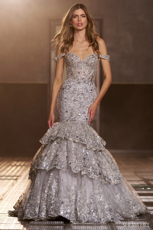 This dress features a sequin lace fabric with a corset bodice, off-the-shoulder straps, and a ruffle tiered skirt. The lace-up back allows for a perfect fit. This gown is glamorous and dramatic and could be ideal for your next prom or formal event.

Sherri Hill 56687