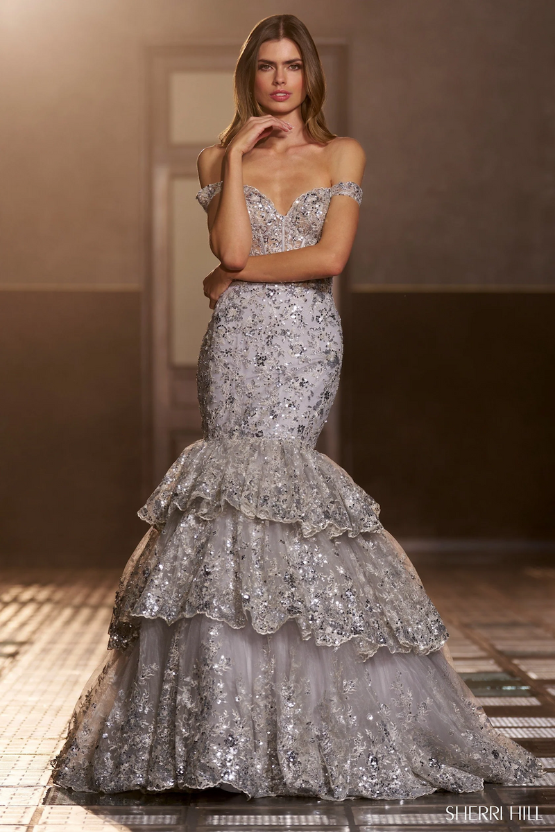 This dress features a sequin lace fabric with a corset bodice, off-the-shoulder straps, and a ruffle tiered skirt. The lace-up back allows for a perfect fit. This gown is glamorous and dramatic and could be ideal for your next prom or formal event.

Sherri Hill 56687