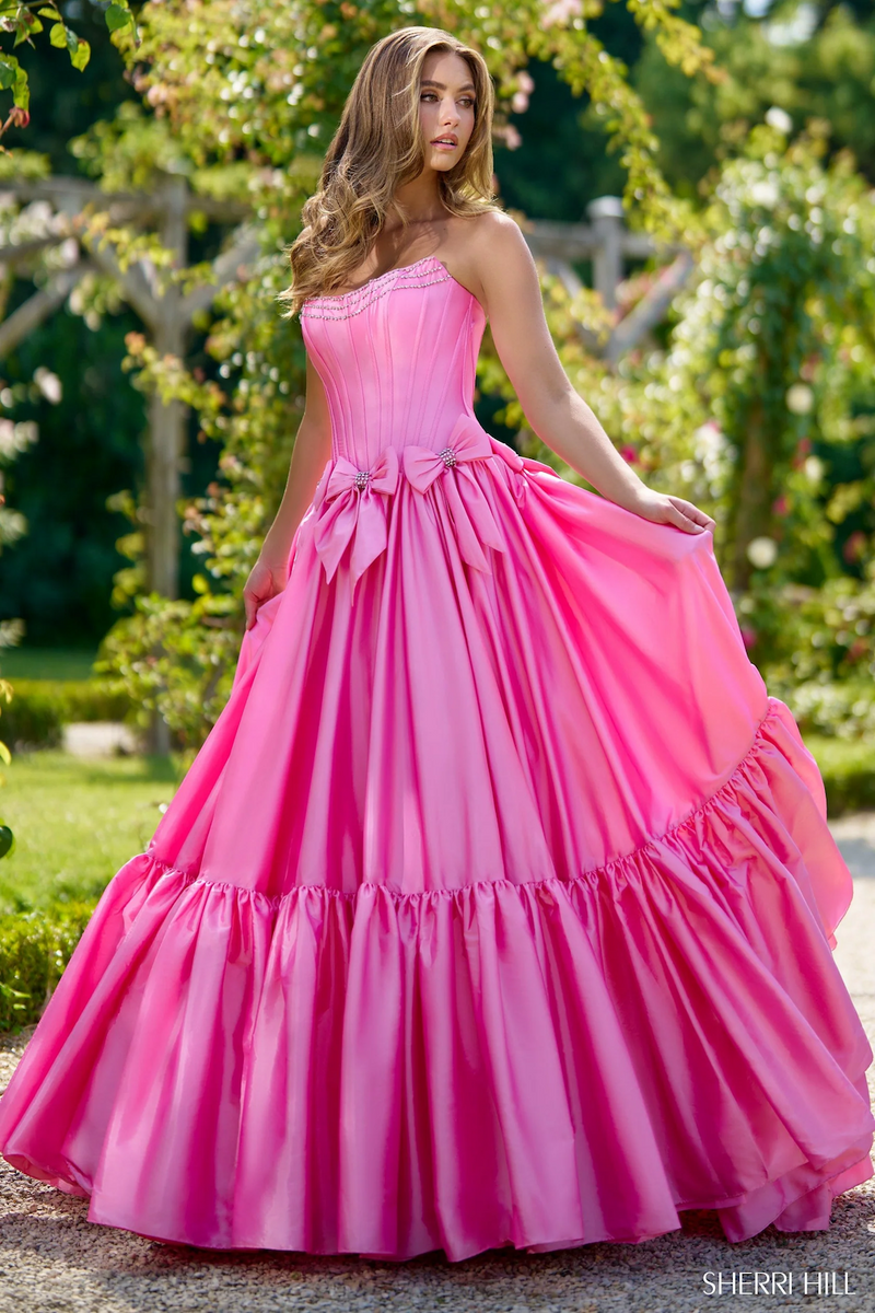 This dress features a strapless neckline with a drop-waist bodice with corset boning. Bow details with beaded embellishments are along the waistline all in a taffeta fabric. This dress is feminine and unique and could be ideal for your next prom or formal event.

Sherri Hill 56958