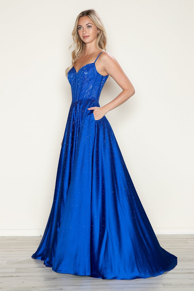 This dress features a bodice with corset boning and spaghetti straps and crystal detailing throughout. The skirt is flowy creating an A-line silhouette with pockets. This dress is timeless and could be ideal for your next prom or formal event!

PY 9610