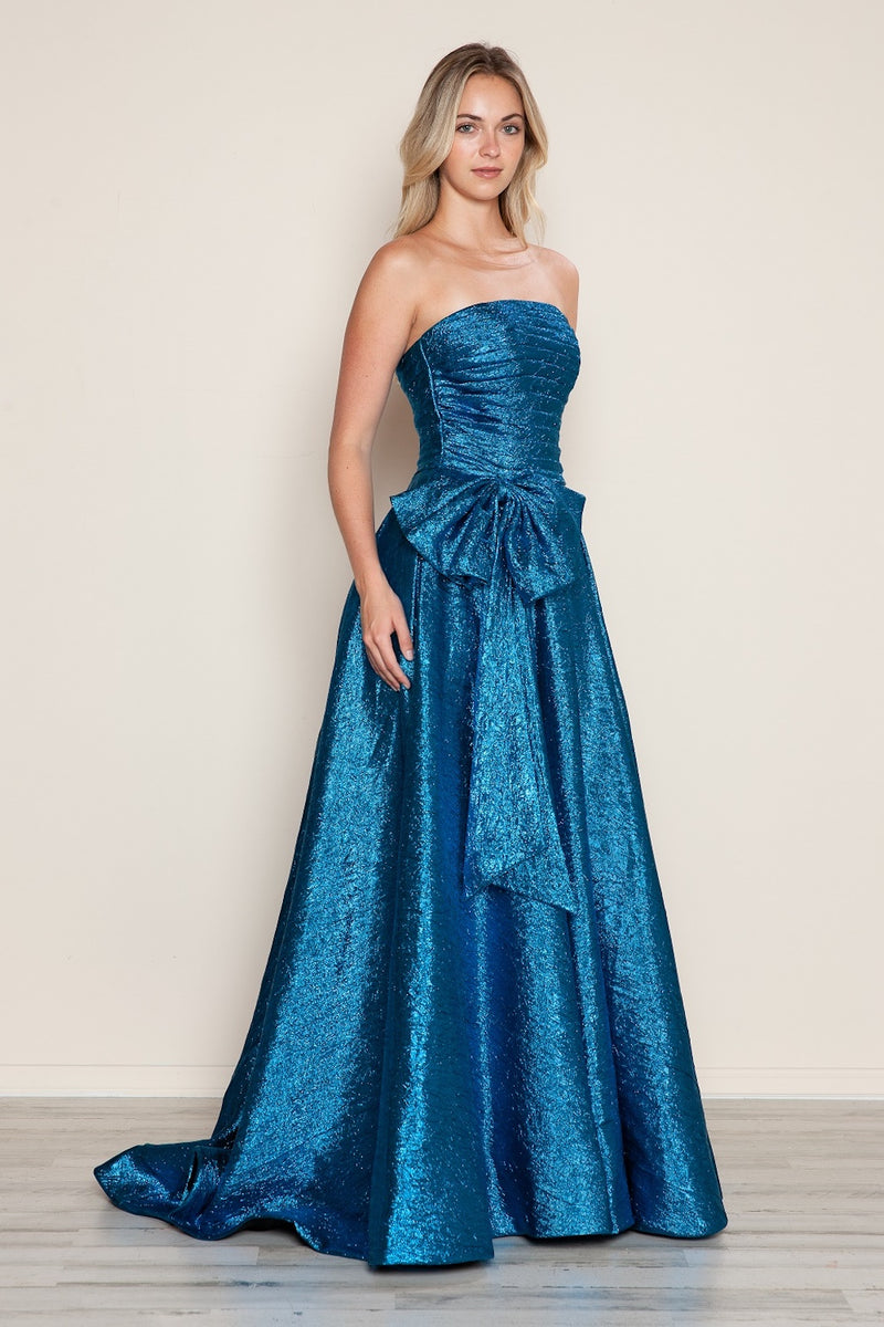 This dress features a strapless neckline with a ruched bodice that has a dramatic bow at the waistline. The metallic taffeta fabric offers an iridescent effect and the A-line silhouette photographs beautifully. This dress may be perfect for your next prom or formal event.

PY 9720