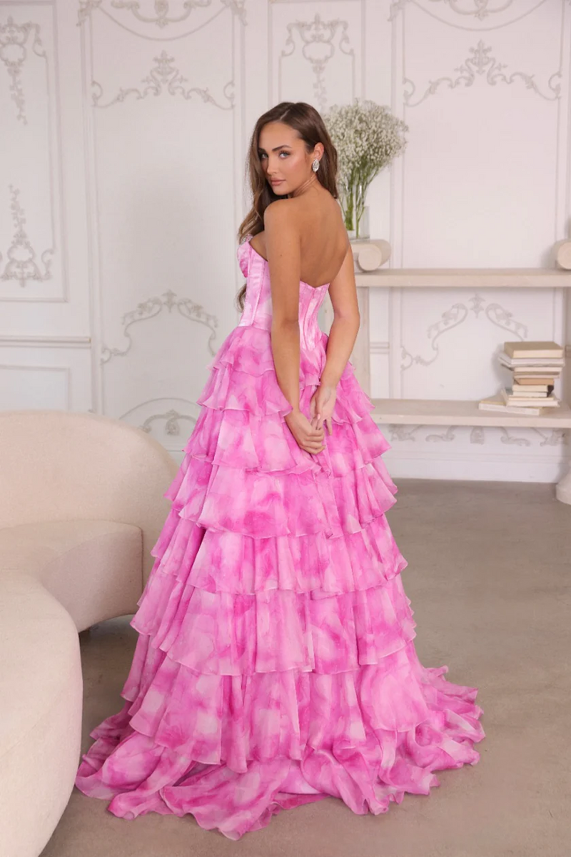 This dress features a strapless sweetheart neckline with a corset bodice that has crystal detailing on the bust. The skirt has layered ruffles which create an A-line silhouette, all in a soft watercolor print fabric. This dress is glamorous and could be ideal for your next prom or formal event.

ARY 26442