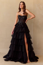 This gown features a ball gown silhouette, strapless neckline, lace up back, a sheer corset bodice with beading along the bodice, and a tiered ruffle skirt. Add a pair or simple heels for a fun prom look.&nbsp;

ACE 9053