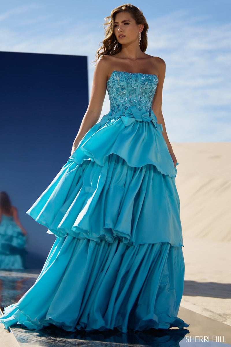 This tiered ruffle ball gown features taffeta fabric with a strapless neckline, a beaded corset bodice and bows along the waistline. This dress is unique and could be ideal for your next pageant or formal event.  Sherri Hill 56838