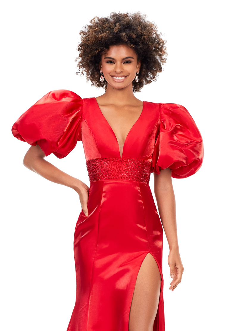 This dress features a v-neckline with oversized puff sleeves. The waistband is embellished with scattered heat set stones and is complete with a lace-up back, fitted silhouette, and a shimmer satin fabric. Style this dress to make it your own at your next prom, pageant or formal event.&nbsp;  Ashley Lauren 11379