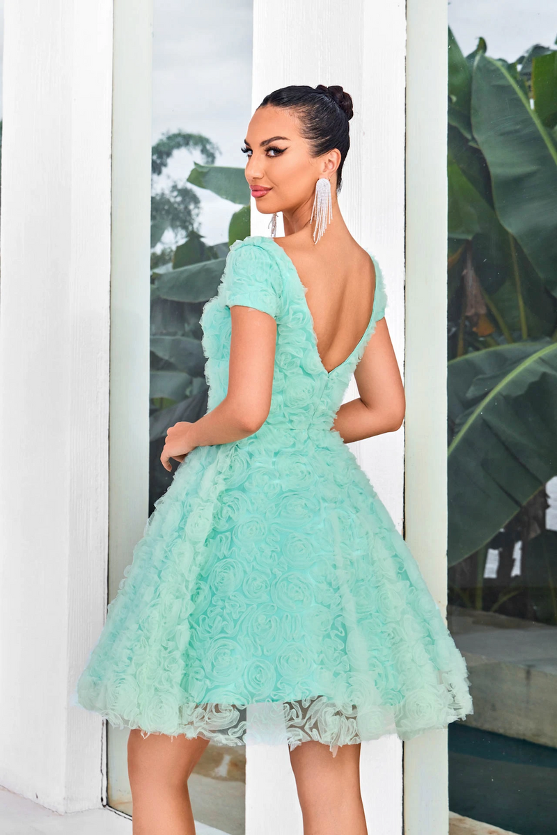 This modest cocktail dress features cap sleeves, and a square neckline with an A-line silhouette. The fabric creates 3D rosettes throughout the dress adding a unique texture. Choose this stunning dress for your next homecoming or formal event!  JAD J24088