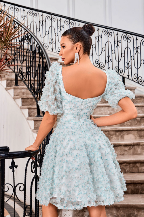 This modest cocktail dress features bell sleeves, a square neckline, and an A-line silhouette. The tulle fabric offers a 3D ruffle texture throughout the design creating an ethereal and bohemian vibe. This dress may be perfect for your next homecoming or formal event!  JAD J24094